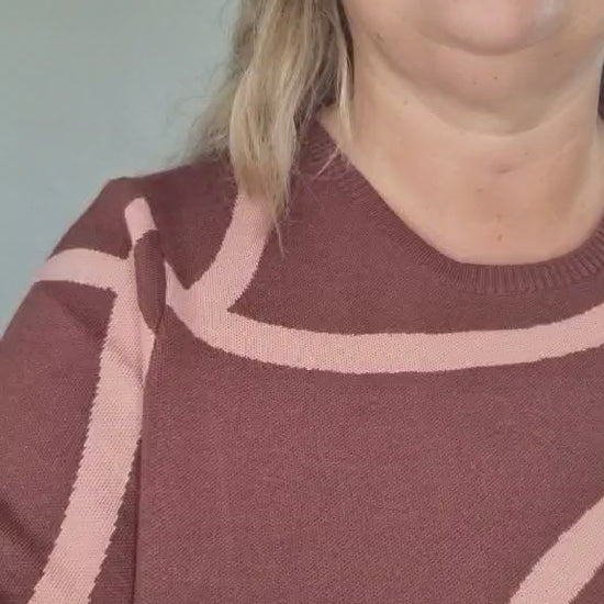 Kvinde i vinrød strik med rosa mønster