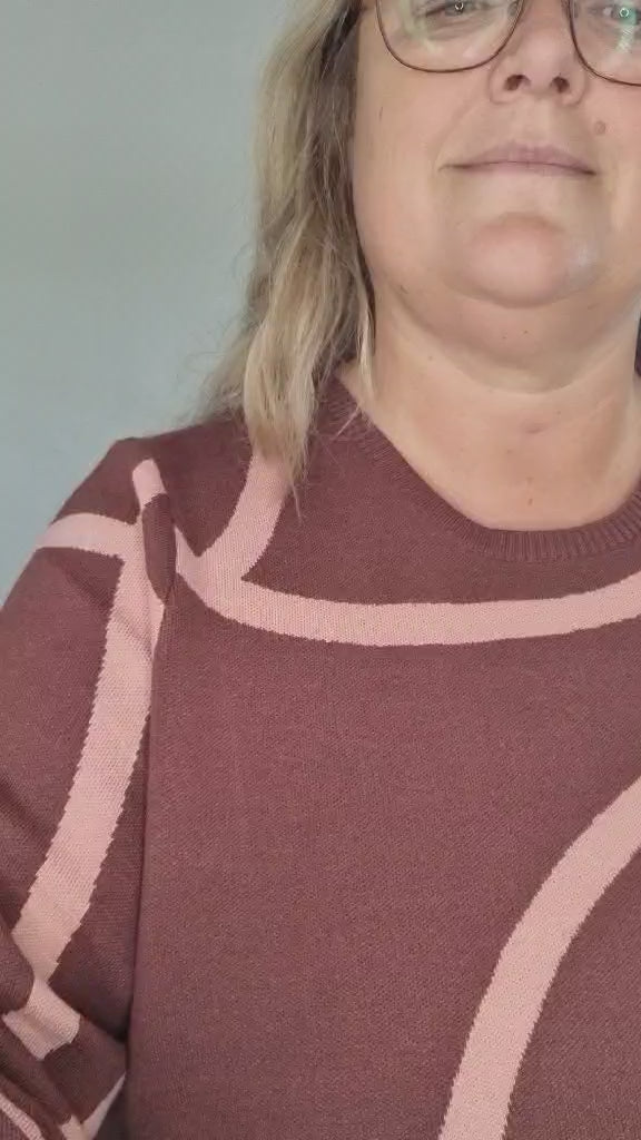 Kvinde i vinrød strik med rosa mønster