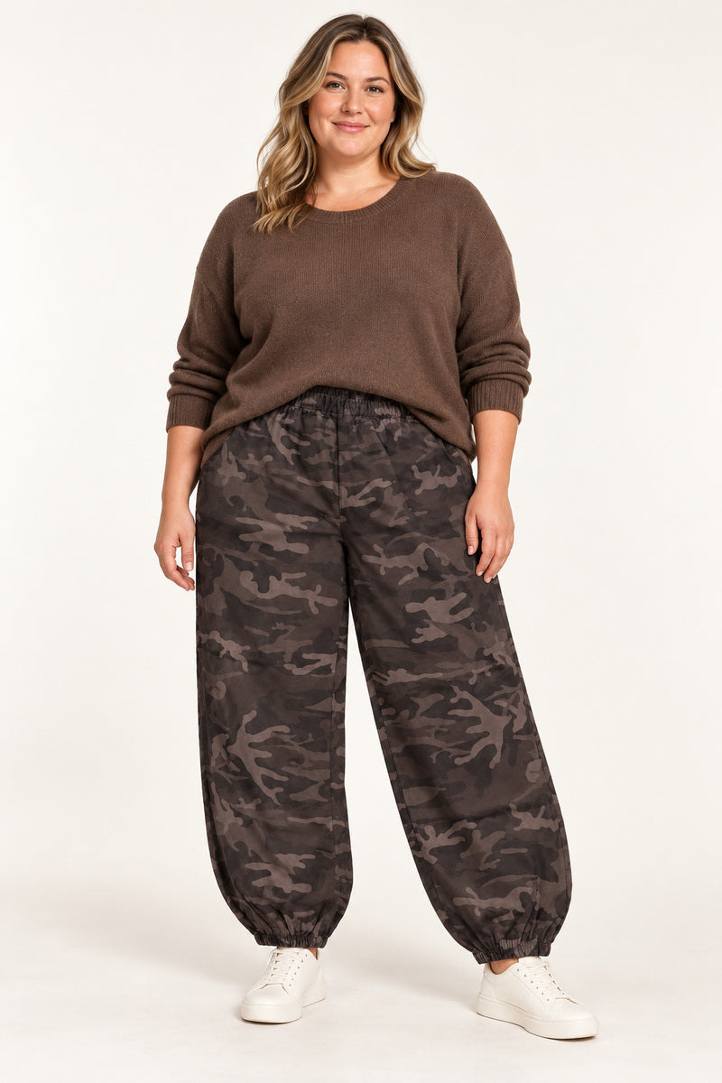 Vanting baggy mirakelbukser i brun camouflage på en plus size-model med brun strik